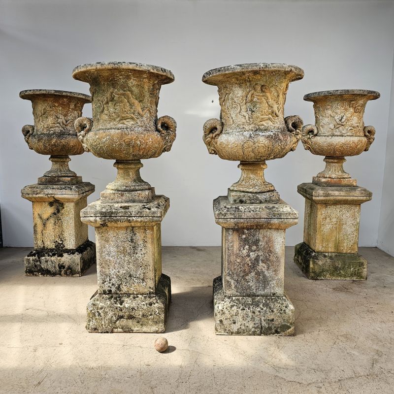 Exceptionnel ensemble de jardin en pierre reconstituée composé de 4 socles à l'antique et 4 enormes vases à têtes de béliers , décor de naïades. Milieu 20ème. Superbe patine du temps.