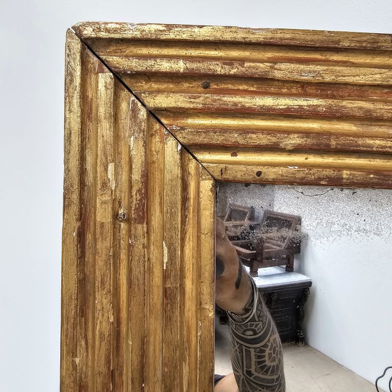 Très grand miroir neoclassique fin 18ème à rainures, sculpté en bois doré. Autre prise de vue