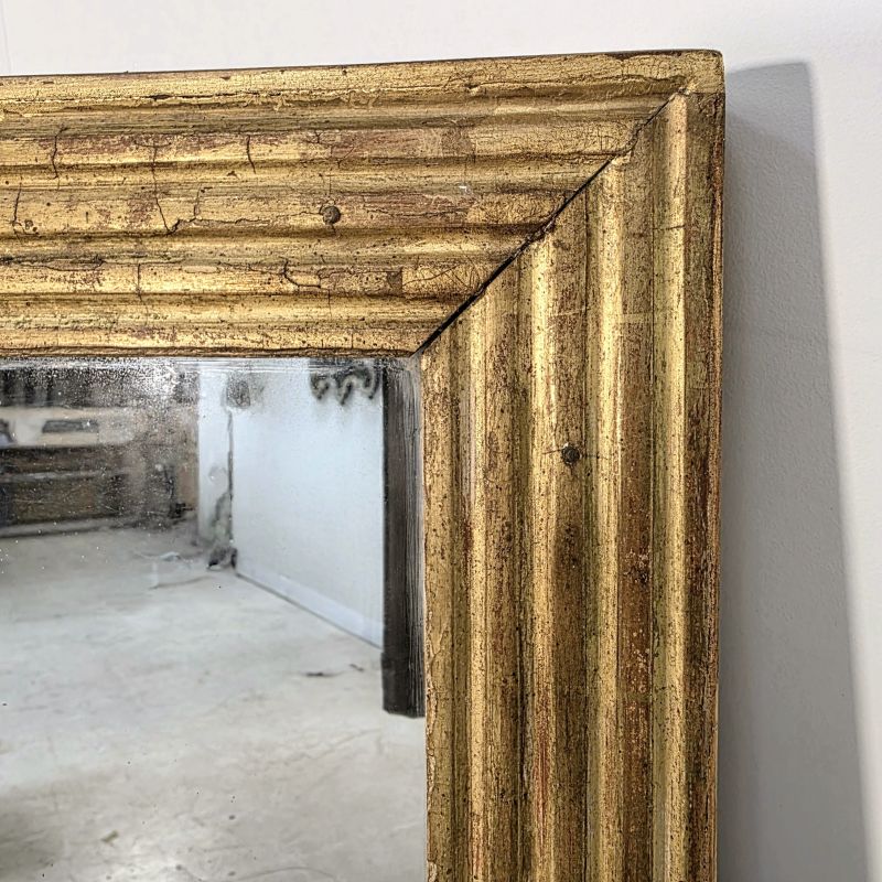 Joli miroir doré à cannelures d'époque 19ème. Autre prise de vue