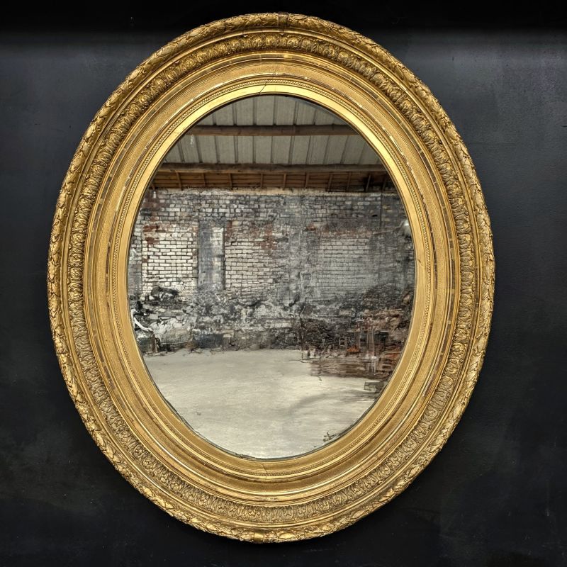 Large 19th oval mirror in gilded wood with gold leaf